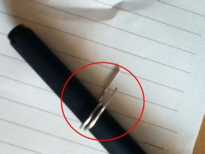 Tie the paper clip around the pen