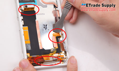 Pry up the three connectors to release the motherboard flex cable ribbon